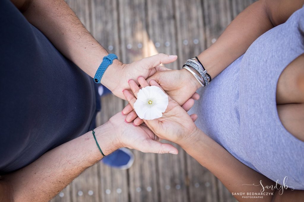 fleur dans les mains des parents représentant le bébé à venir